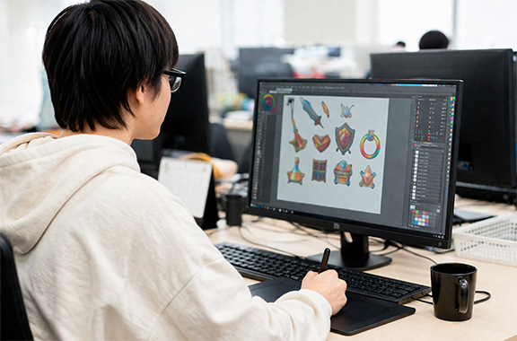 PCモニターの画面をみながらペンタブレットで操作する人