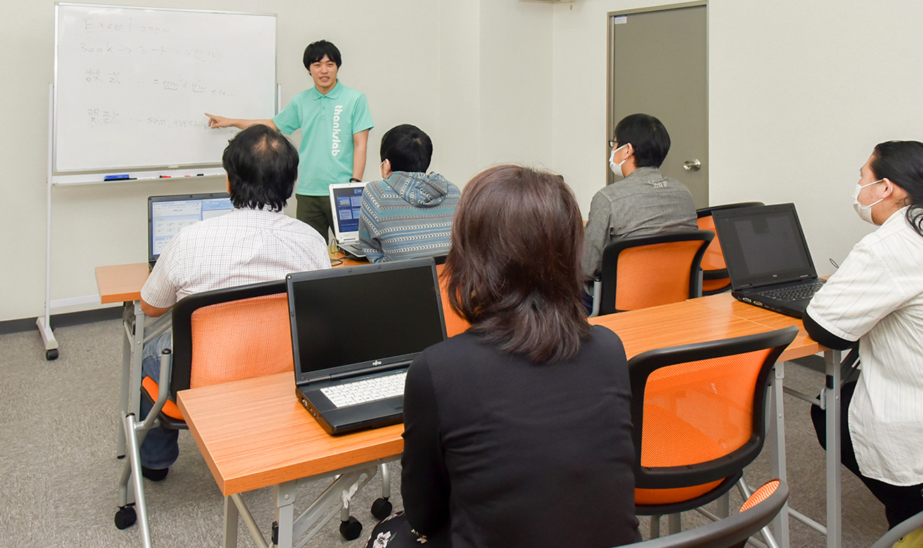 ホワイトボードを使って説明する社員と話をきく参加者たち