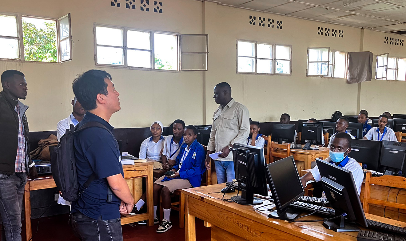 ルワンダの教室で現地の生徒たちにプレゼンする人