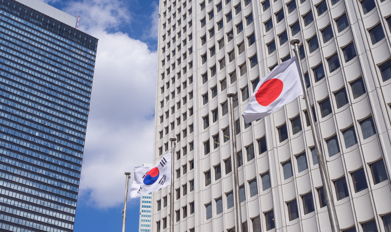 ピルを背に、韓国と日本の旗がなびいている