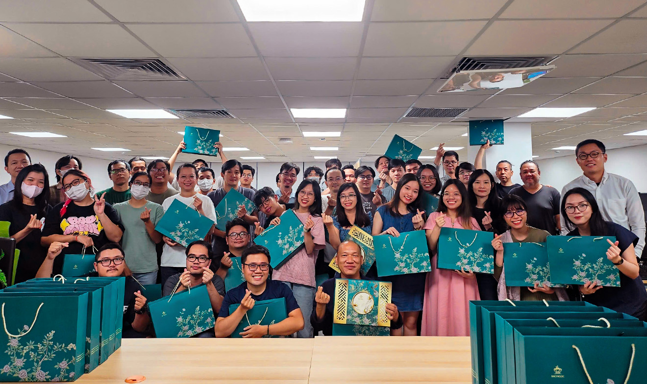 緑のギフトバックをもったベトナムの社員たち