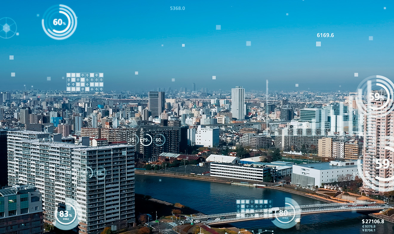 白い数値とグラフ（背景は青い空、ビル群と川）