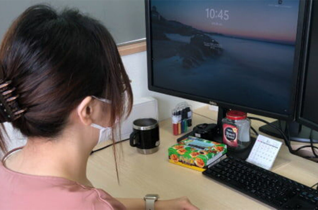 PCモニターの画面をみている人の後ろ姿