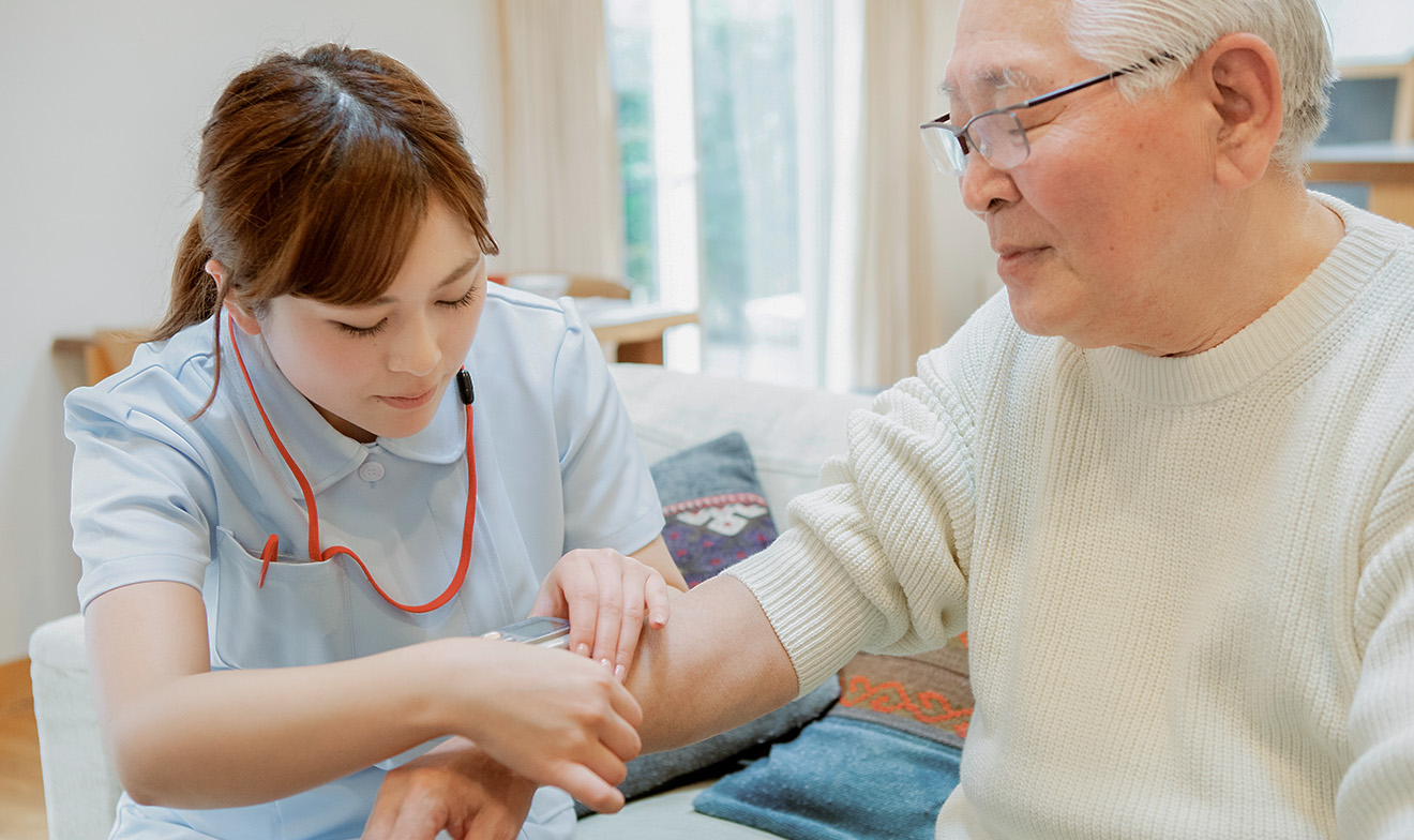 高齢者の血圧を計測する看護師